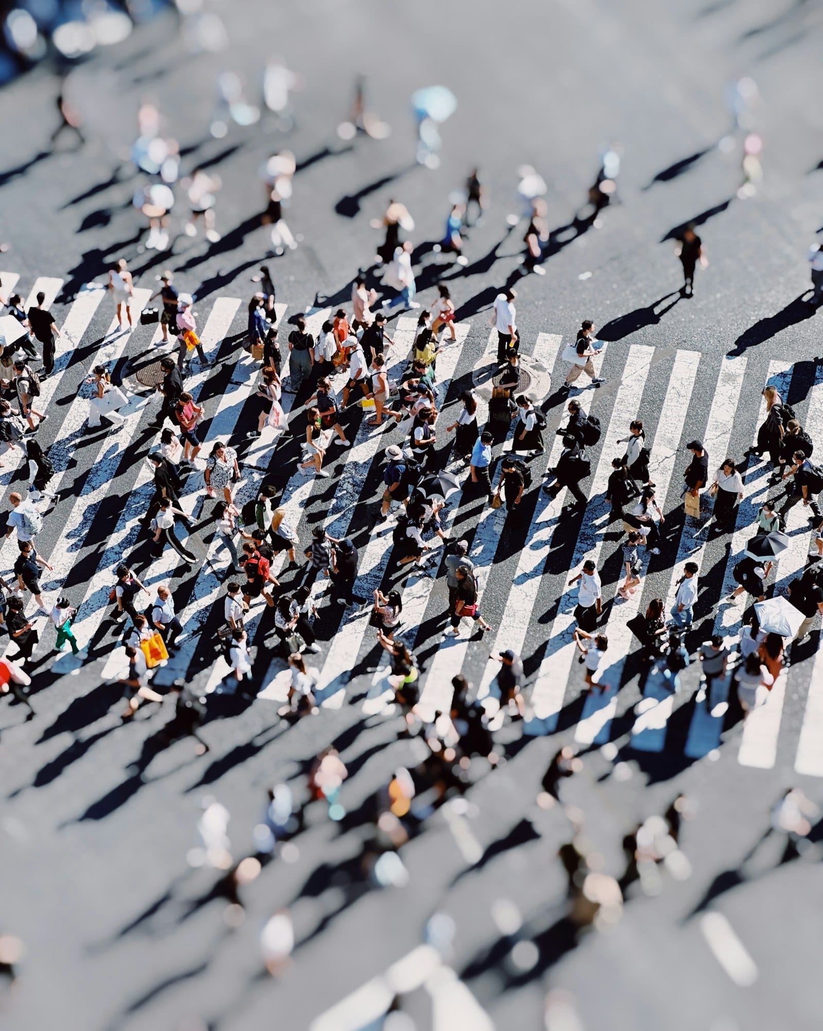 A crowd crossing a city street, seen from above