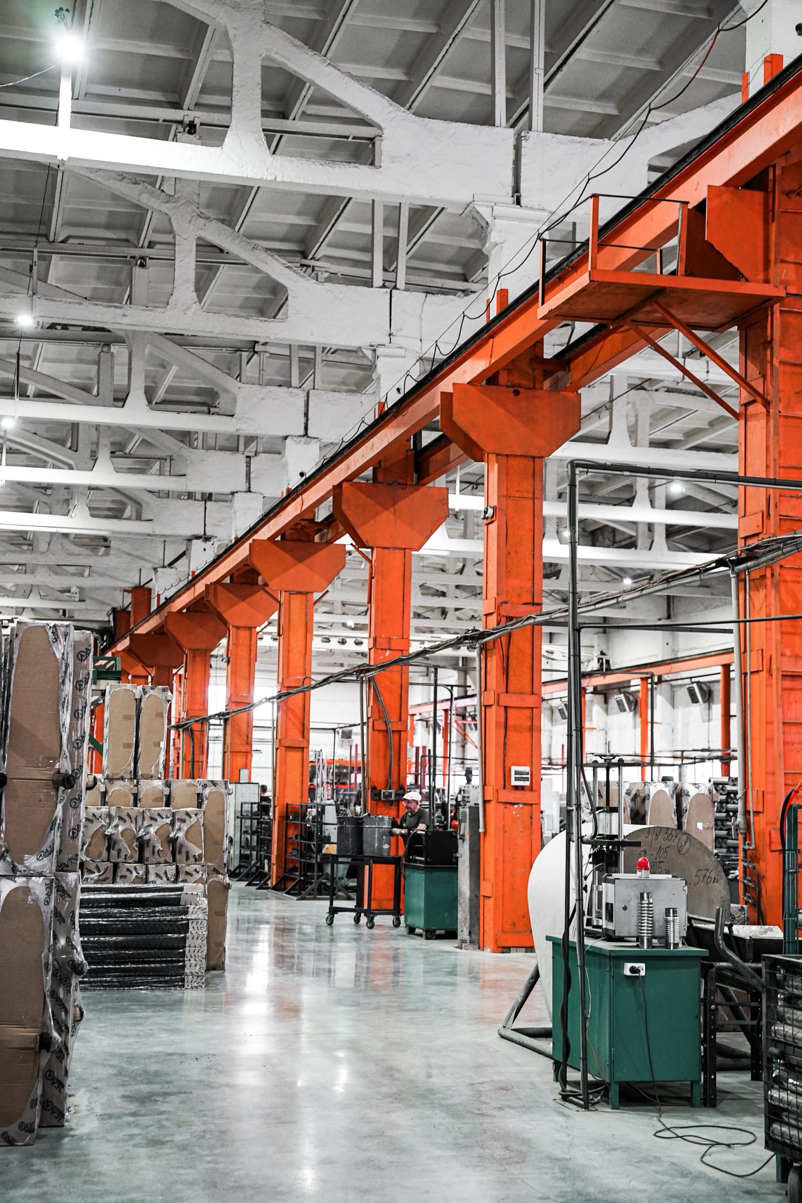 Production hall with orange steel columns and machines
