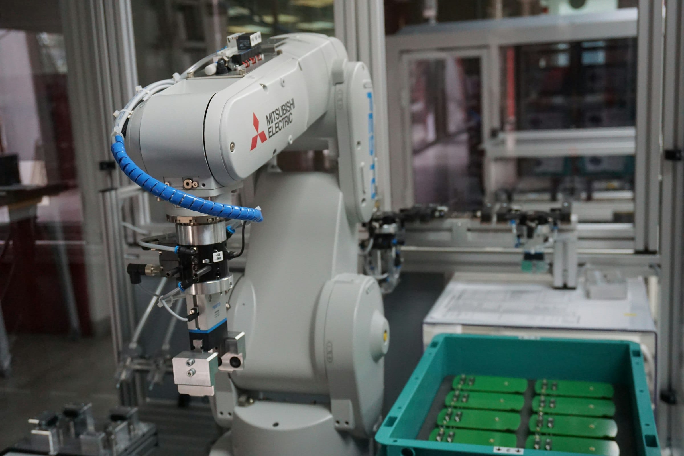 An industrial robot arm picking parts from a tray