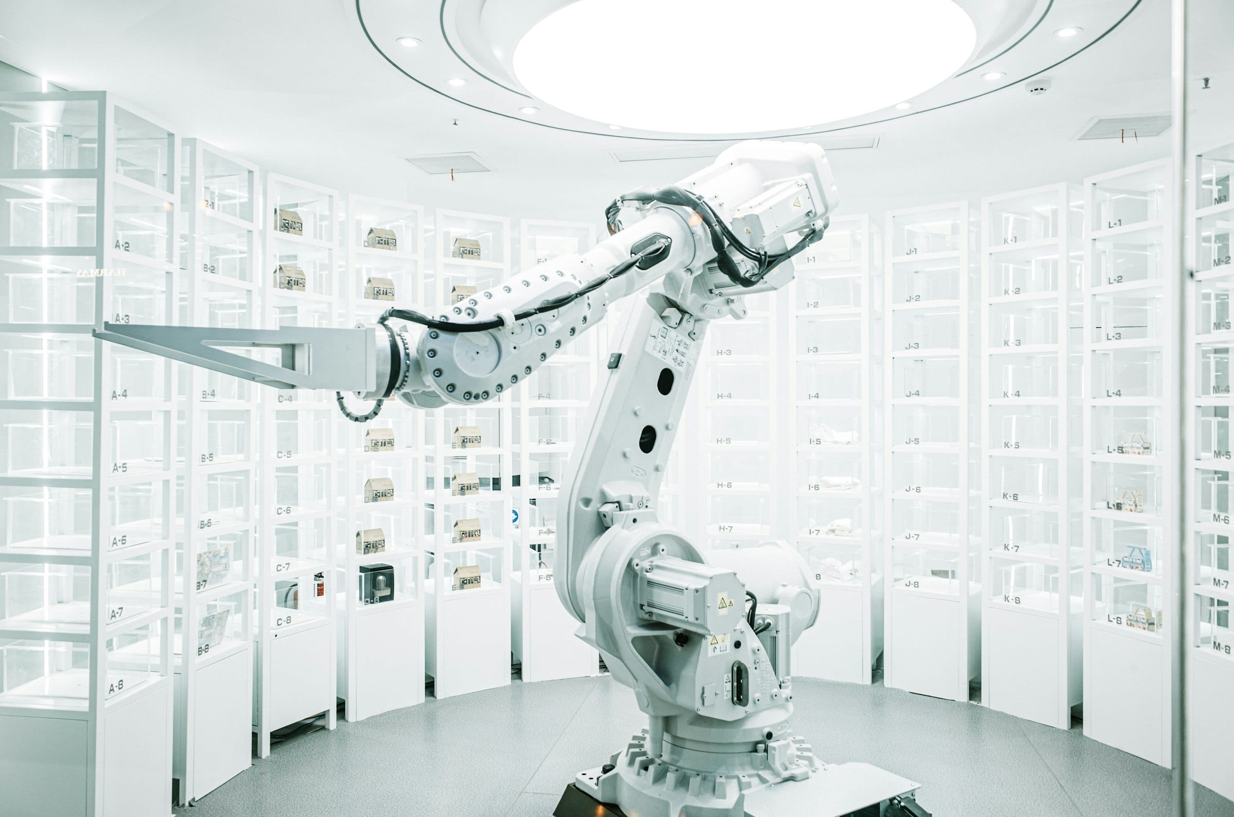 A robot arm among shelves of small boxes in an automated store