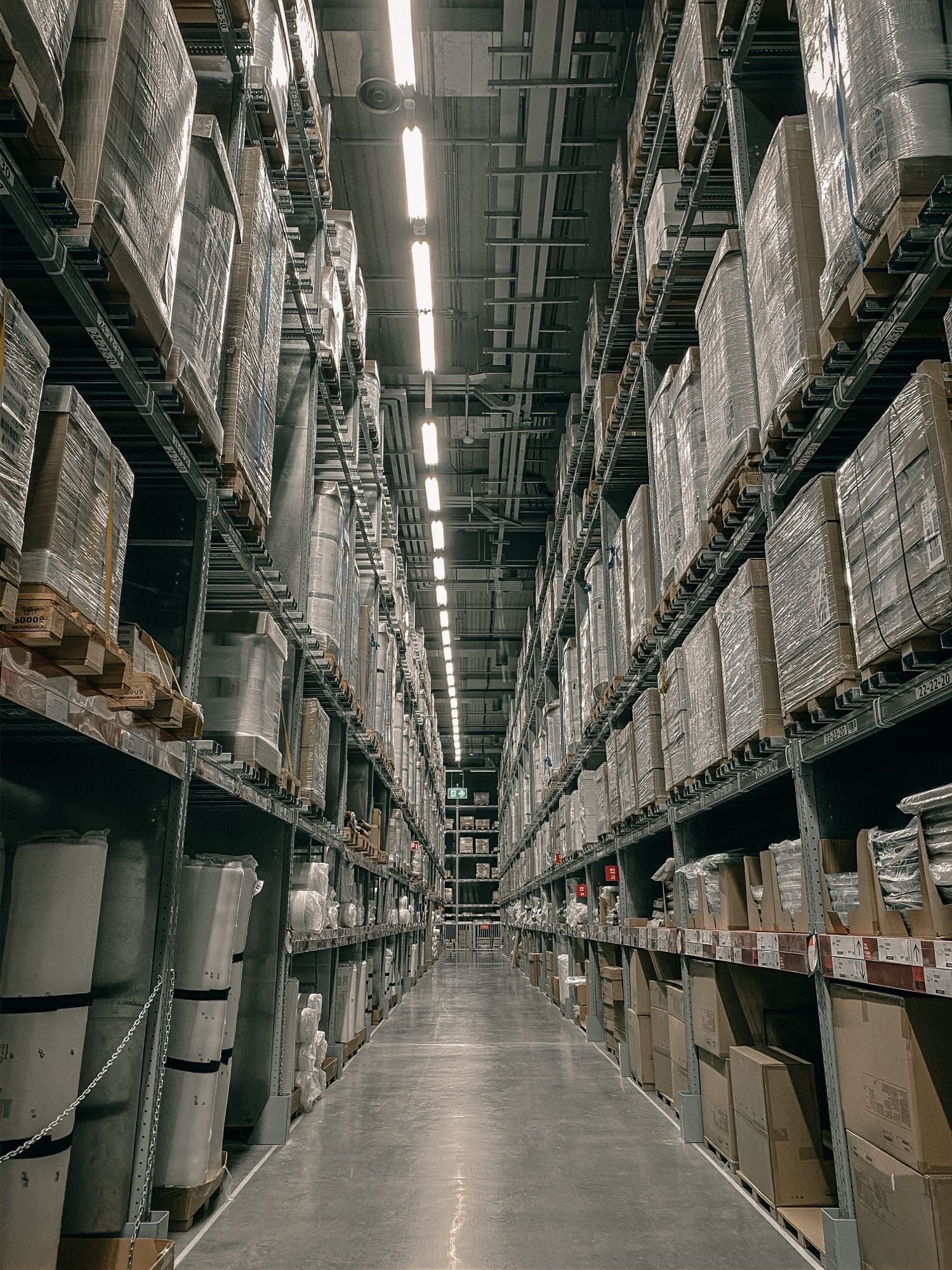 Aisle between high racks stacked with boxes in a distribution warehouse